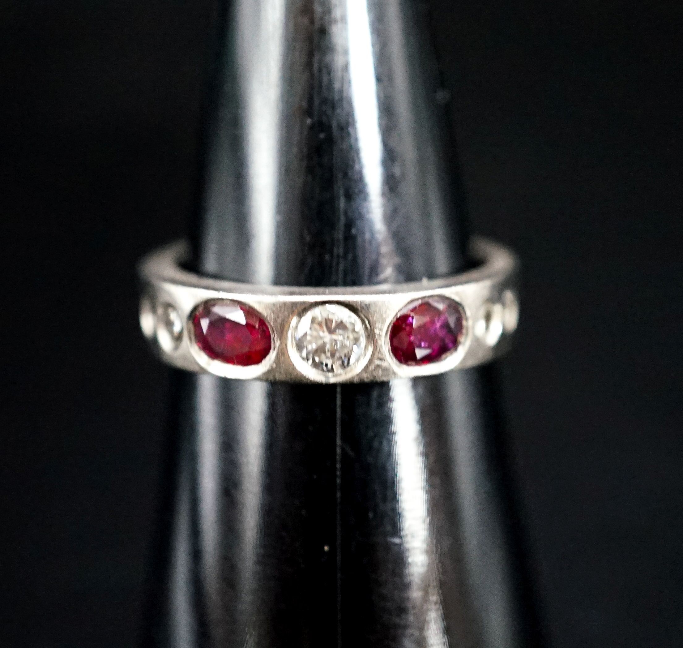 A white metal and gypsy set ruby and diamond set half hoop ring, size M, gross 6.1 grams.